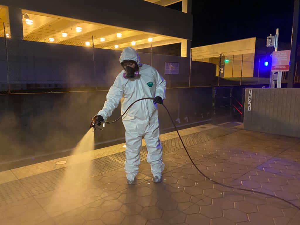 Professional decontaminating a train station.