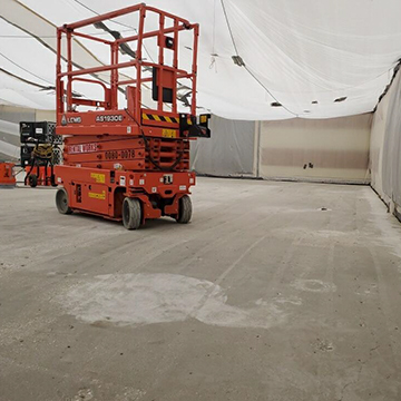 An empty room with scissor lift vehicle.